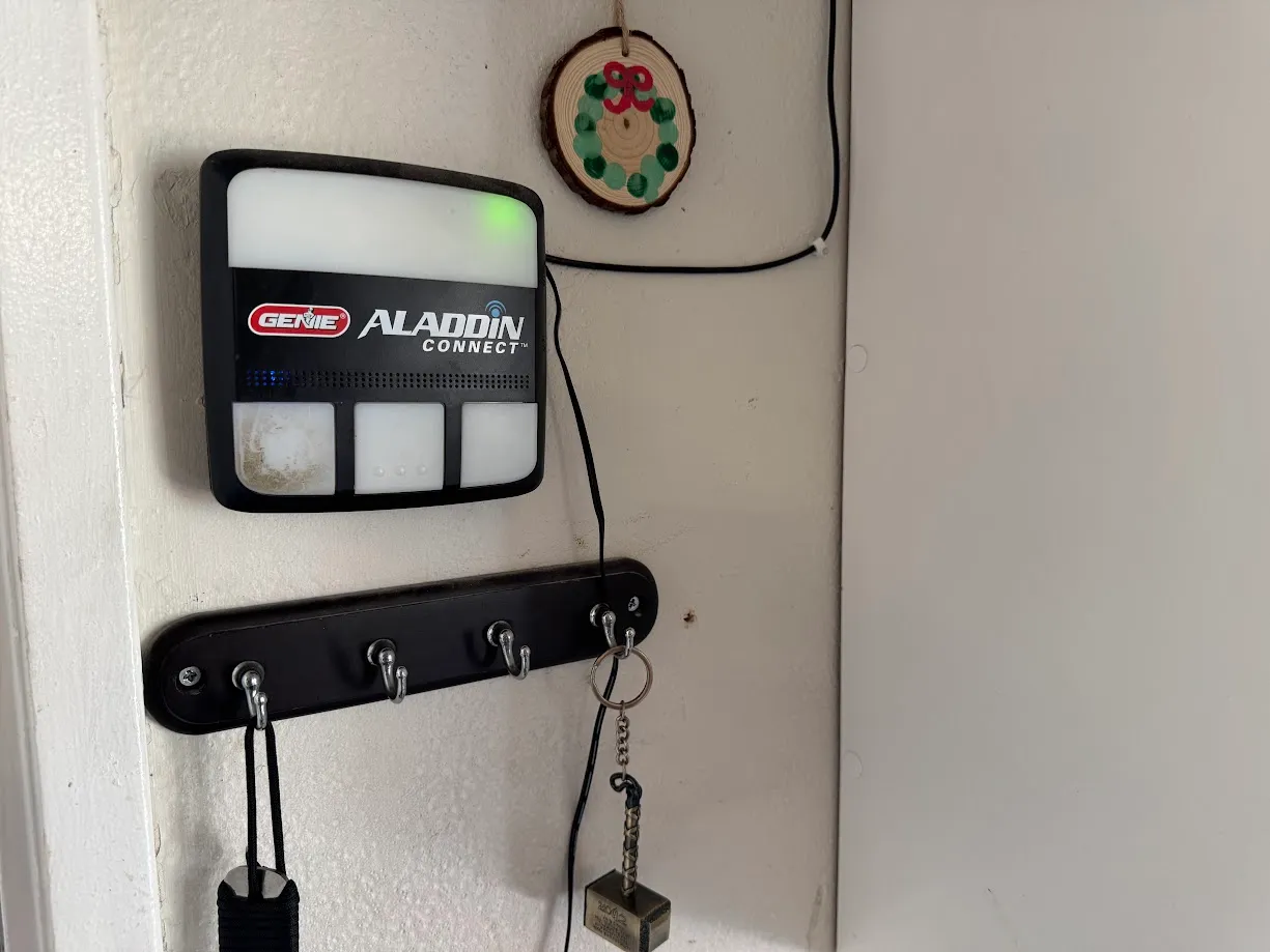 The Genie Aladdin Connect console on the garage wall, wired into the opener with the two-conductor cable I ran.